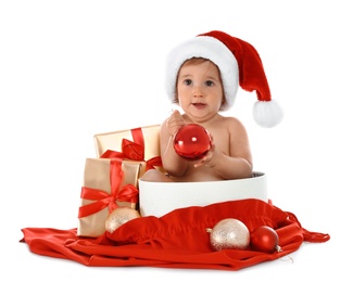 Photo of Cute little baby wearing Santa hat with Christmas gifts sitting in box on white background