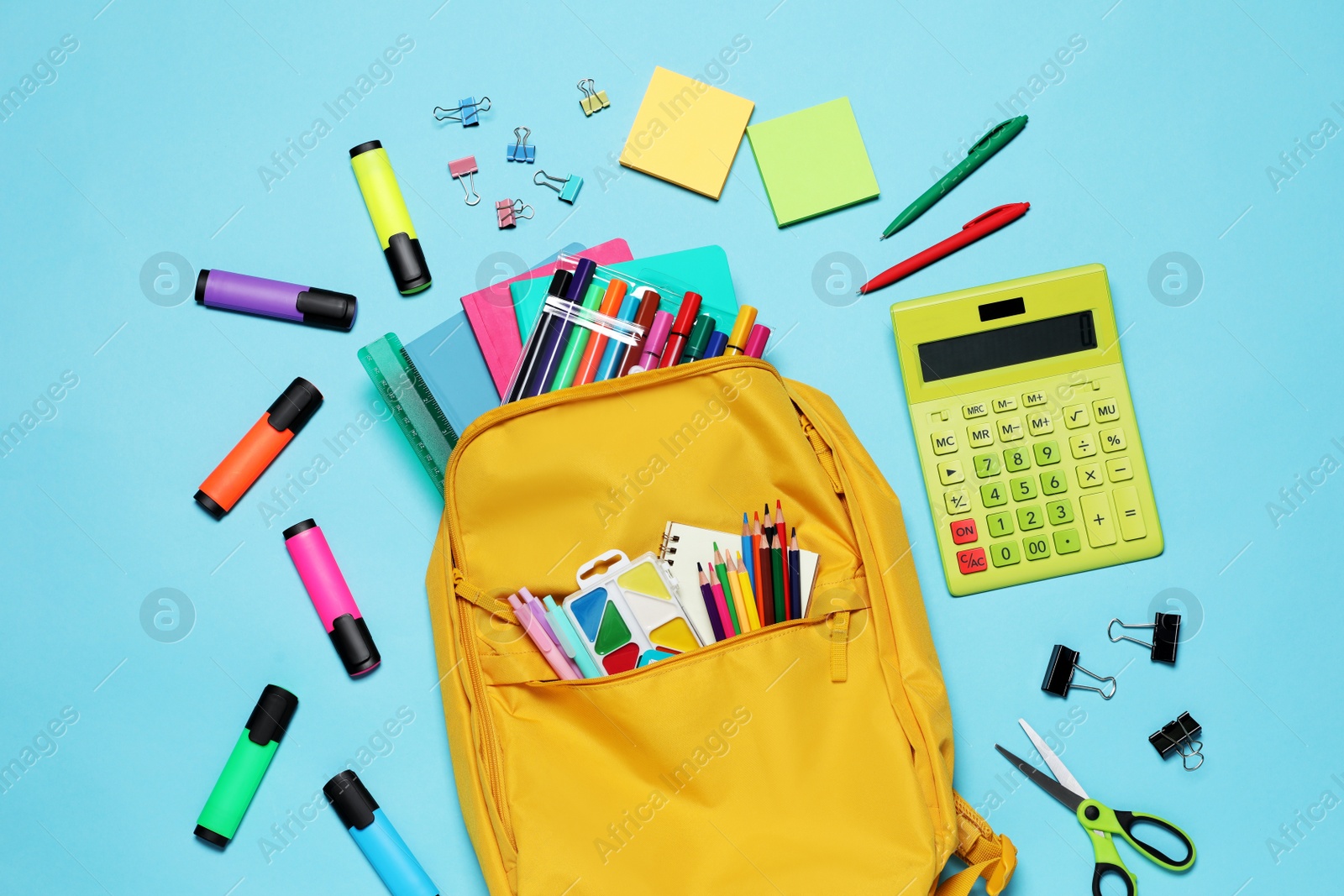 Photo of Backpack with different school stationery on light blue background, flat lay