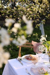 Photo of Stylish table setting with beautiful spring flowers in garden