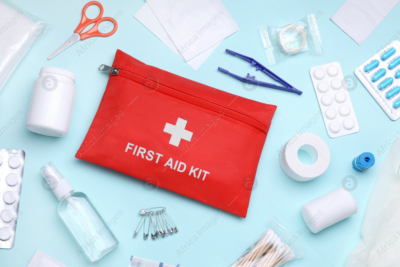 Photo of Flat lay composition with first aid kit on light blue background