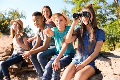 Photo of Group of children with binoculars outdoors. Summer camp