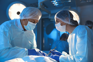 Photo of Team of professional doctors performing operation in surgery room