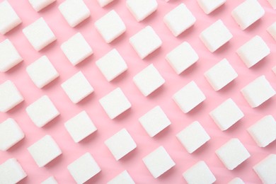 White sugar cubes on pink background, top view