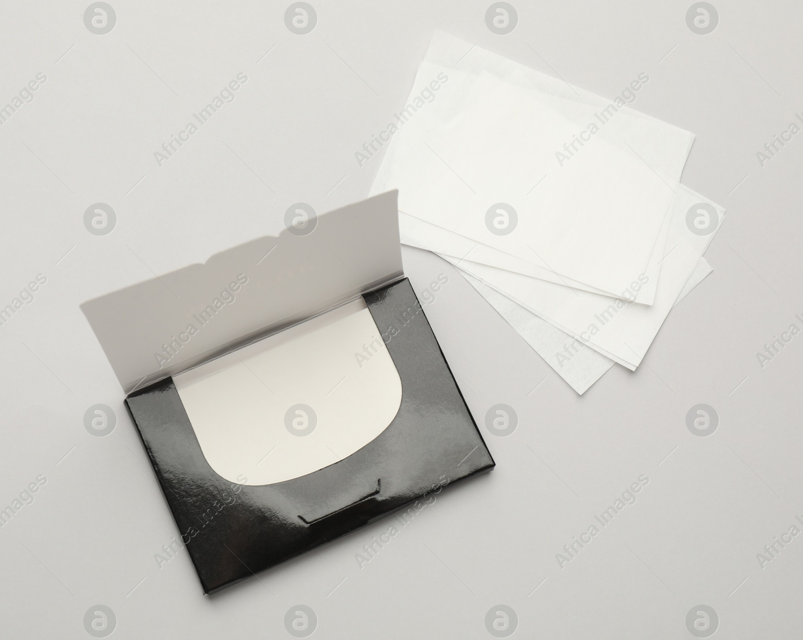 Photo of Package with facial oil blotting tissues on light grey background, flat lay. Mattifying wipes