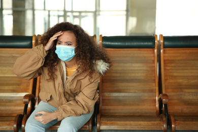 African-American woman with disposable mask indoors. Virus protection