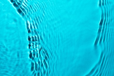 Image of Rippled surface of clear water on light blue background, closeup