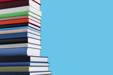 Photo of Stack of hardcover books on light blue background. Space for text