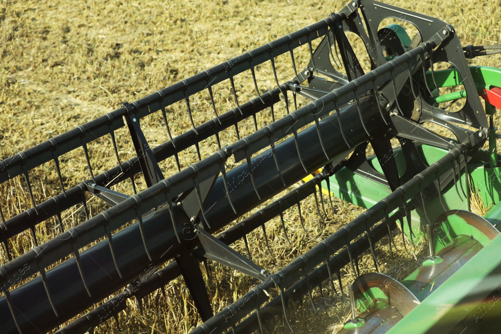 Photo of Modern combine harvester in agricultural field, closeup view of reel