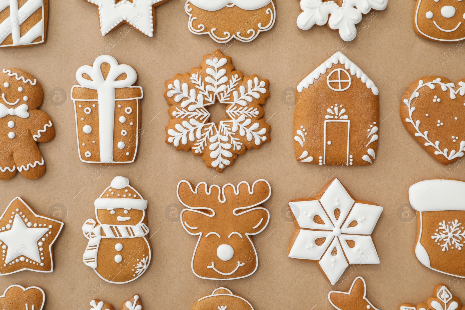 Photo of Different Christmas gingerbread cookies on brown background, flat lay