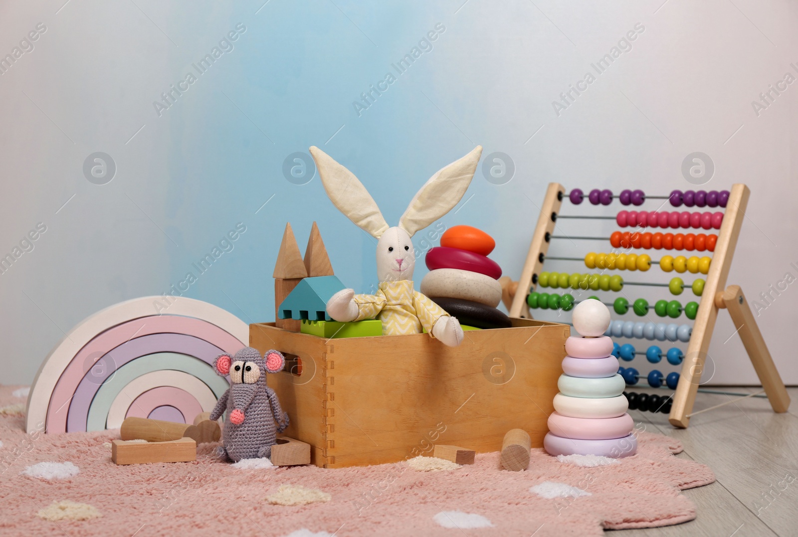 Photo of Set of different toys on rug near light wall