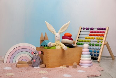 Photo of Set of different toys on rug near light wall