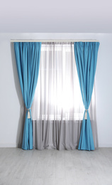 Window with elegant curtains in empty room