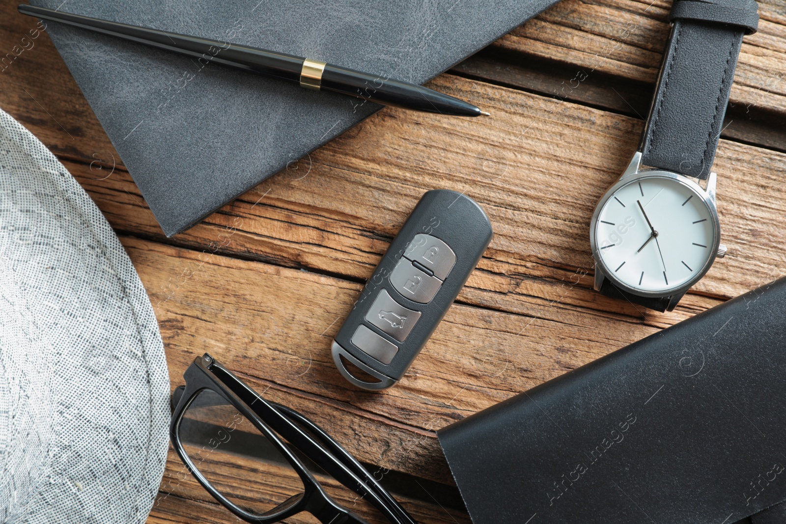 Photo of Flat lay composition with male accessories and remote car key on wooden background