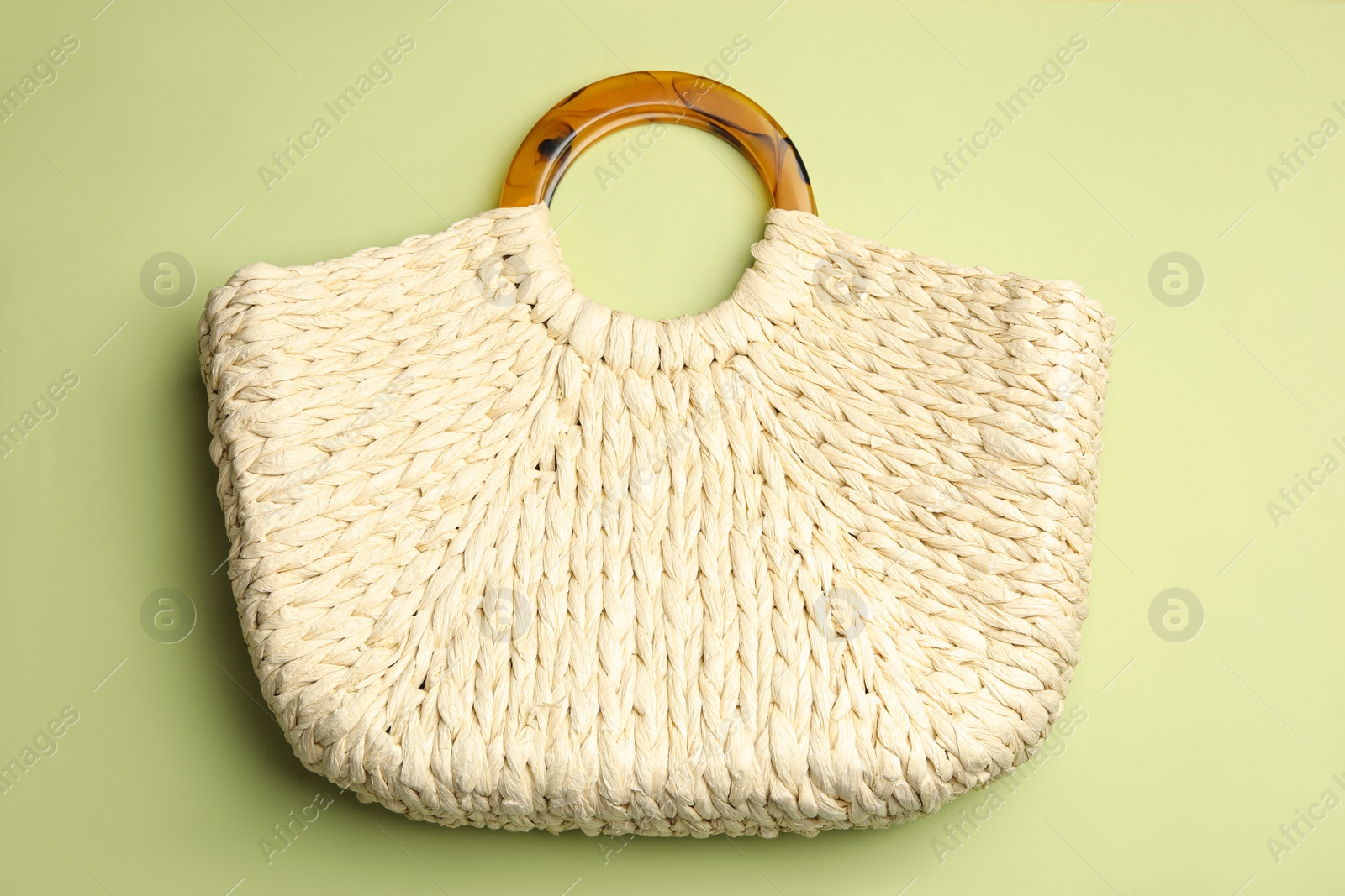 Photo of Stylish knitted woman's bag on light green background, top view