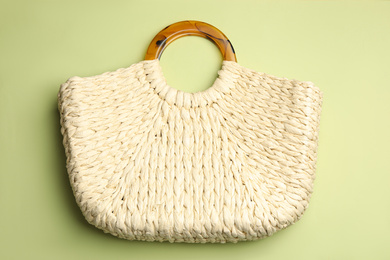 Stylish knitted woman's bag on light green background, top view