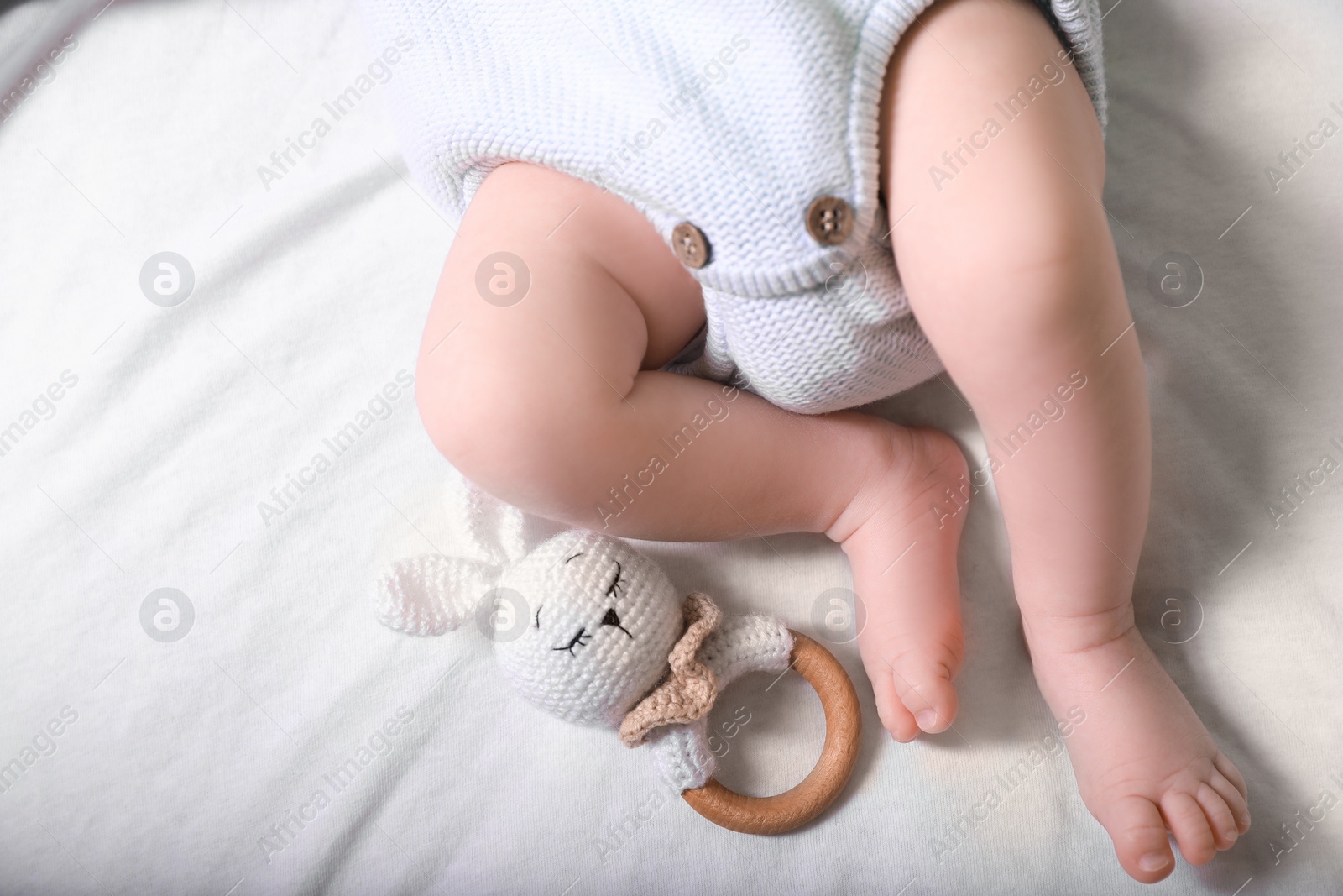 Photo of Newborn baby with toy bunny lying on bed, top view