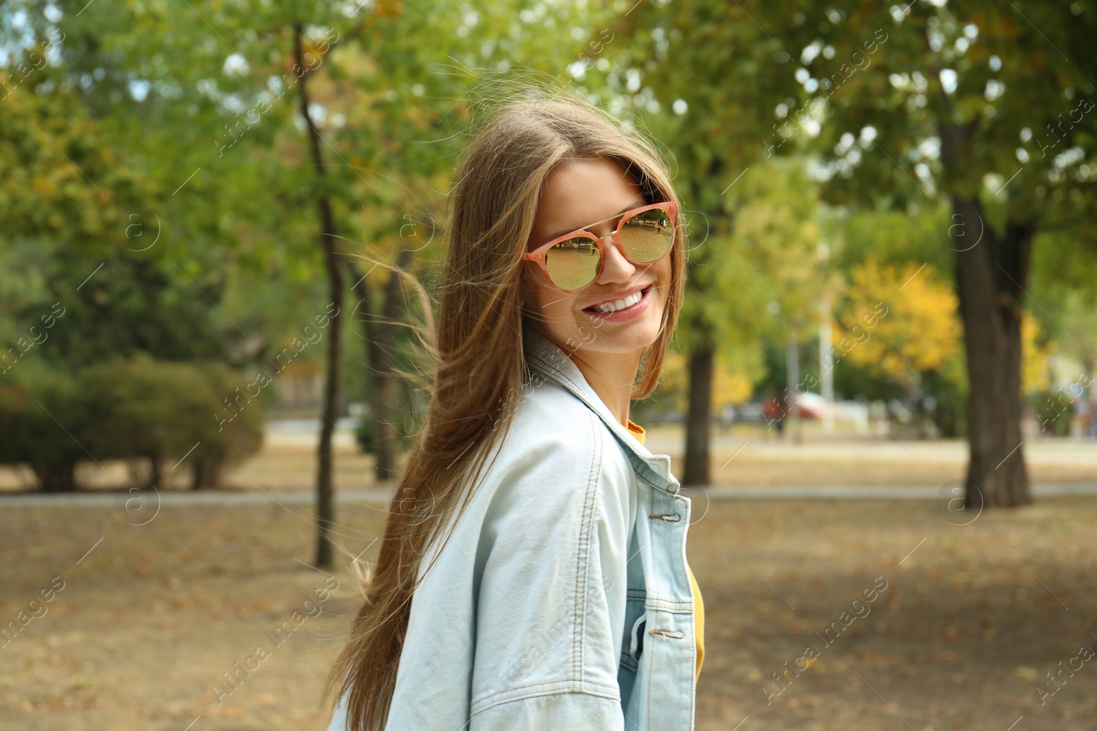 Photo of Young woman wearing stylish sunglasses in park