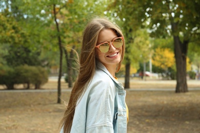 Young woman wearing stylish sunglasses in park