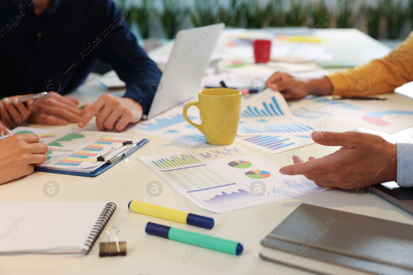 Photo of Team of employees working with charts at table, closeup. Startup project