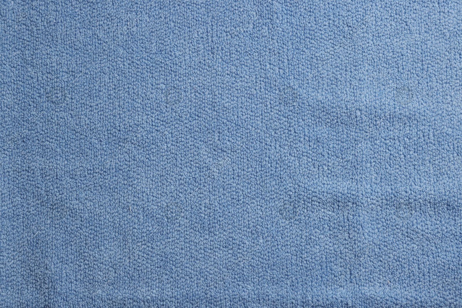 Photo of Soft blue towel as background, top view