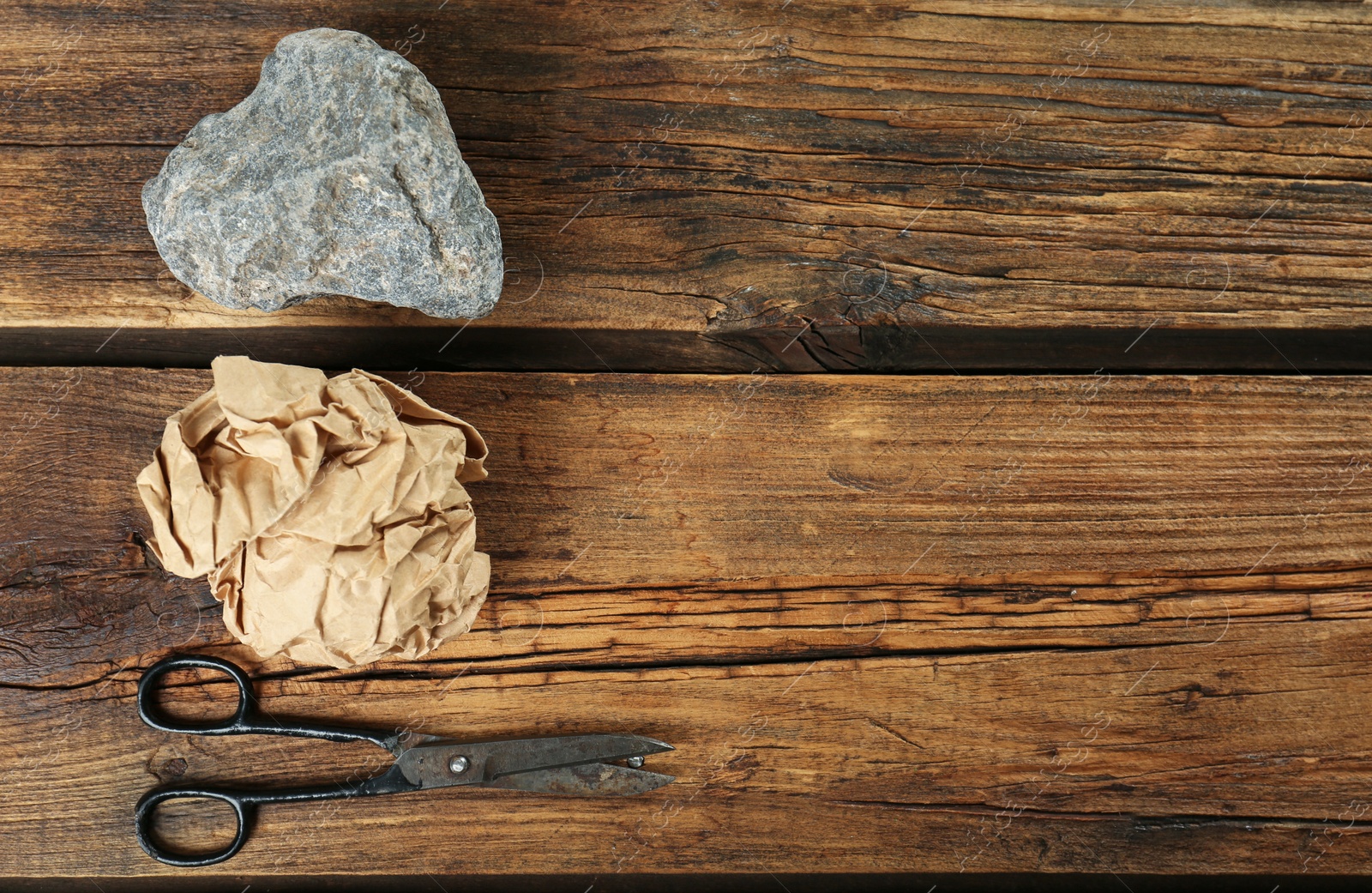 Photo of Flat lay composition with rock, paper and scissors on wooden background. Space for text