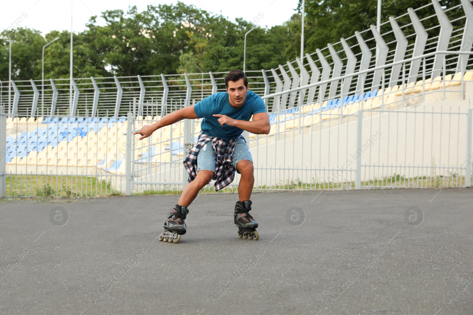 Photo of Handsome young man roller skating outdoors. Recreational activity