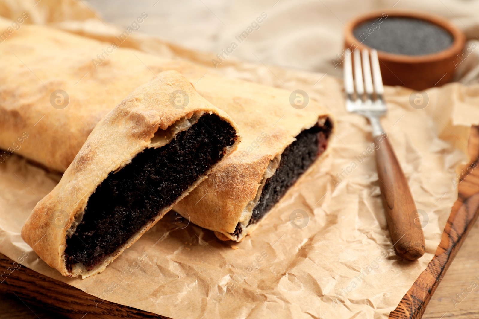 Photo of Delicious strudel with poppy seeds and cherries on table, closeup