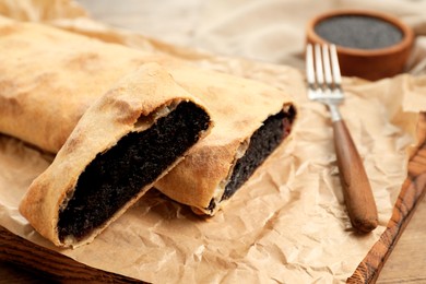 Photo of Delicious strudel with poppy seeds and cherries on table, closeup