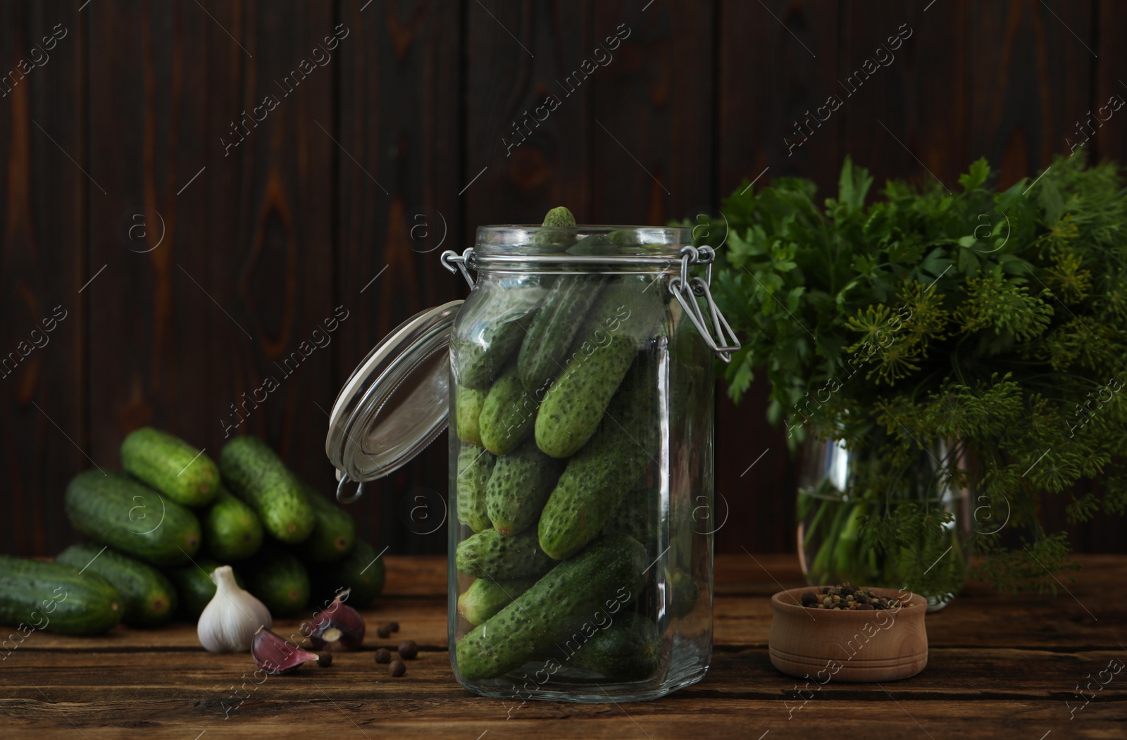 Photo of Pickling jar with fresh cucumbers on wooden table
