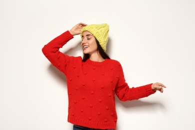 Photo of Young woman in warm sweater and hat on white background. Celebrating Christmas