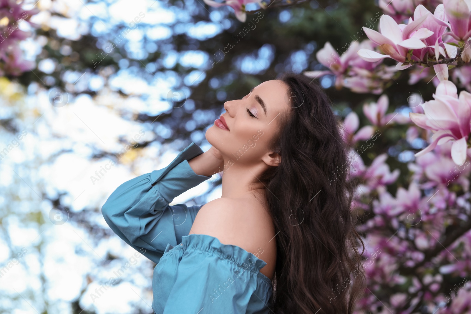 Photo of Beautiful woman near blossoming magnolia tree on spring day