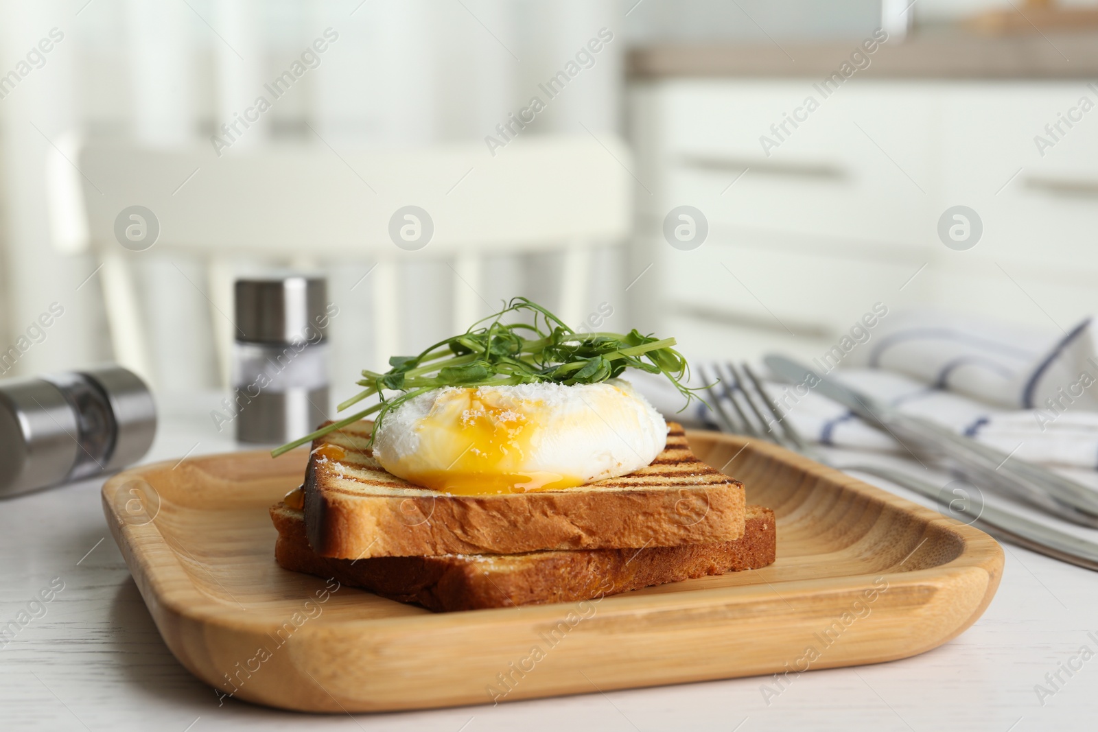 Photo of Delicious poached egg with toasted bread and sprouts served on white wooden table