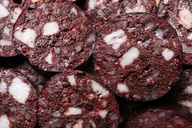 Slices of tasty blood sausage as background, top view