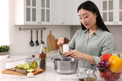 Beautiful woman cooking at countertop in kitchen