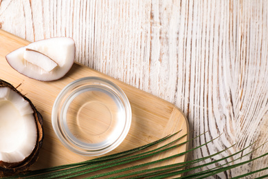 Photo of Coconut oil on white wooden table, flat lay