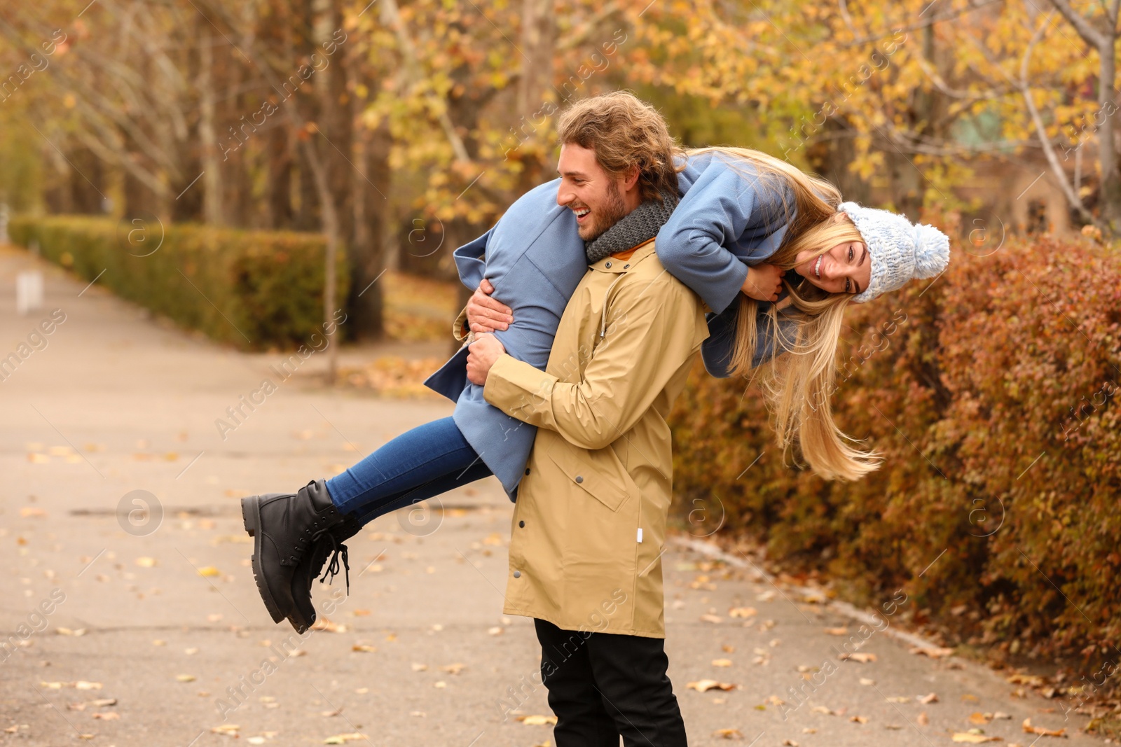 Photo of Young romantic couple having fun in park on autumn day