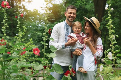 Photo of Happy family in Ukrainian national clothes outdoors