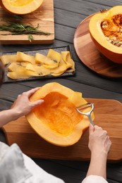 Photo of Woman slicing fresh pumpkin at grey wooden table, above view