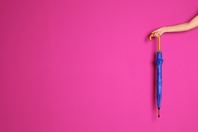 Photo of Woman holding beautiful umbrella on color background with space for design