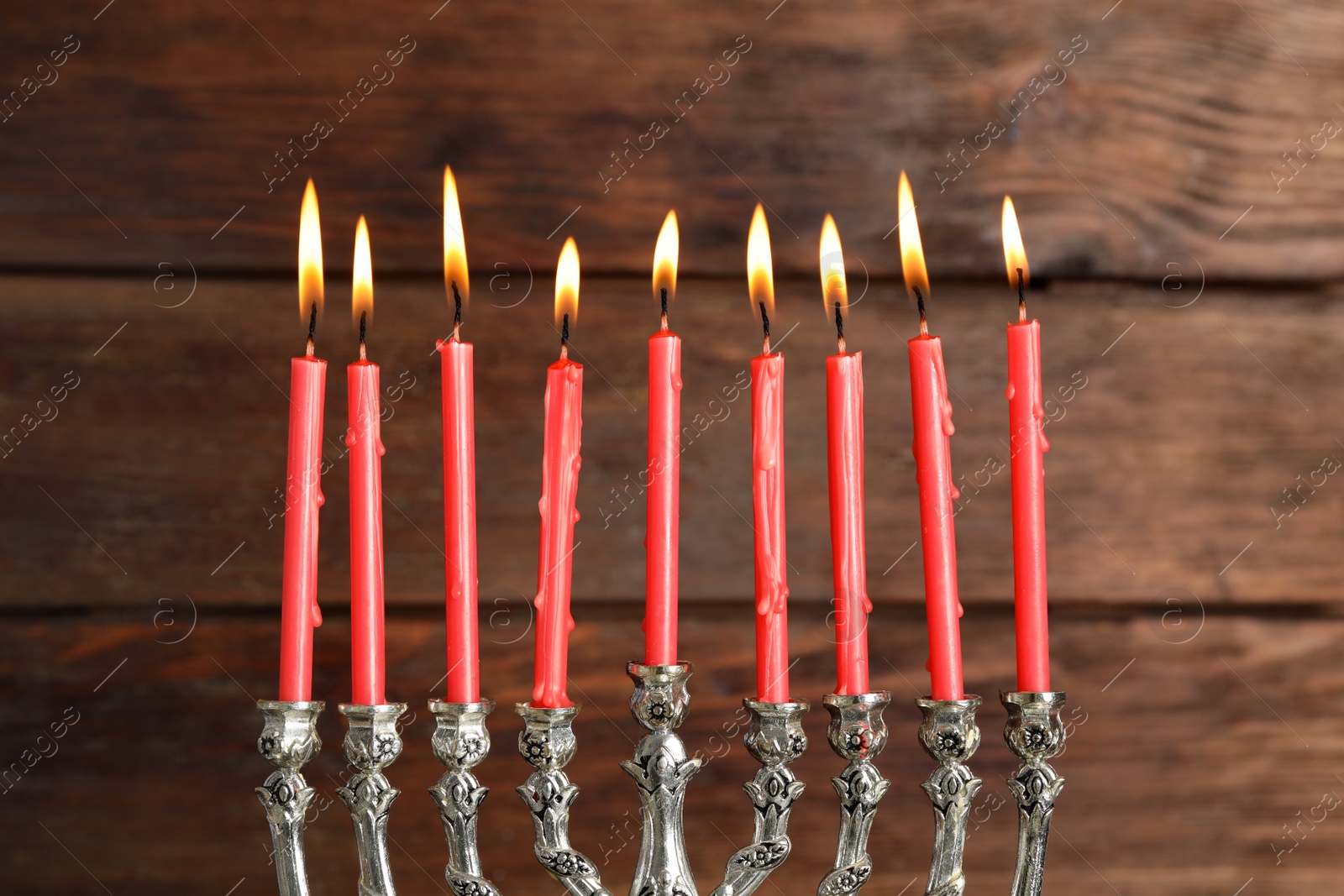 Photo of Silver menorah with burning candles on wooden background. Hanukkah celebration