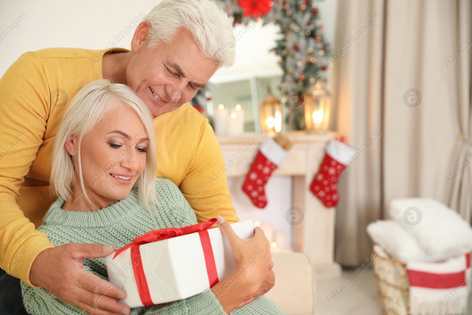 Photo of Happy mature couple with Christmas gift at home