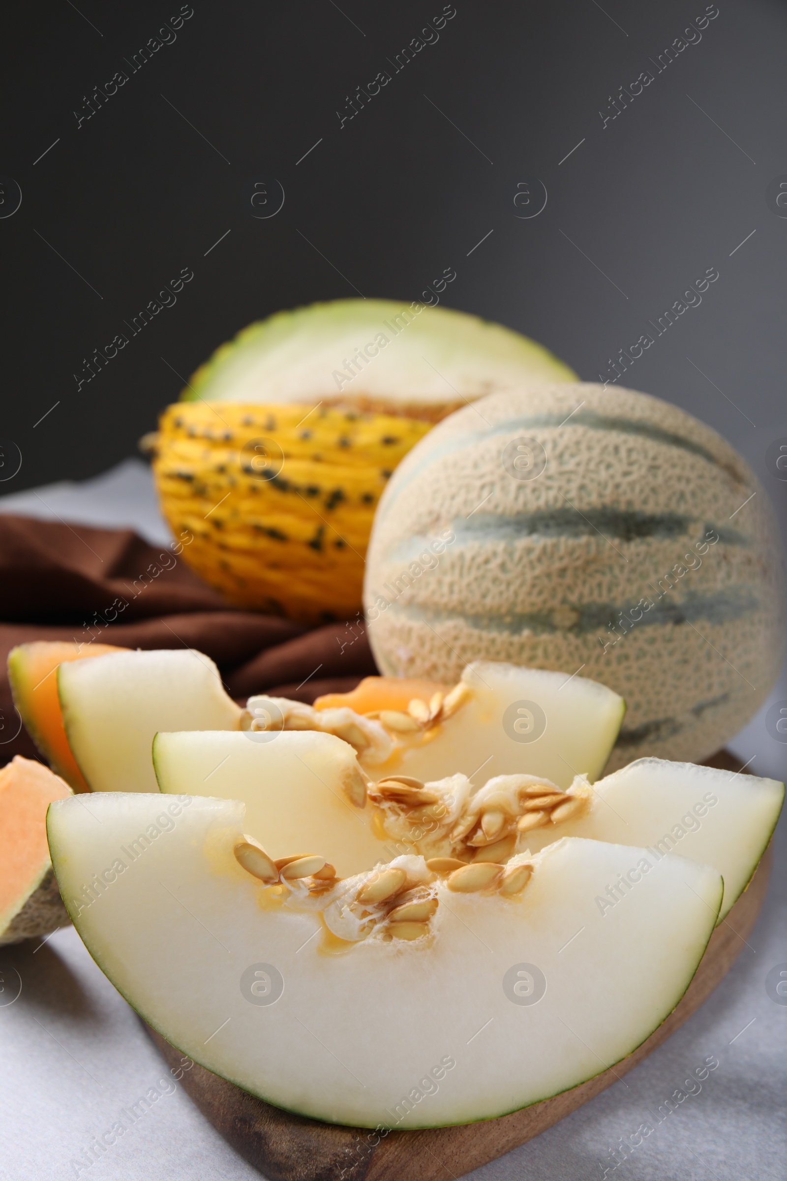 Photo of Tasty colorful ripe melons on light grey table