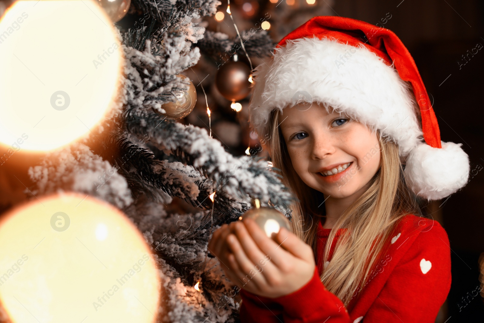 Photo of Cute little child near Christmas tree at home