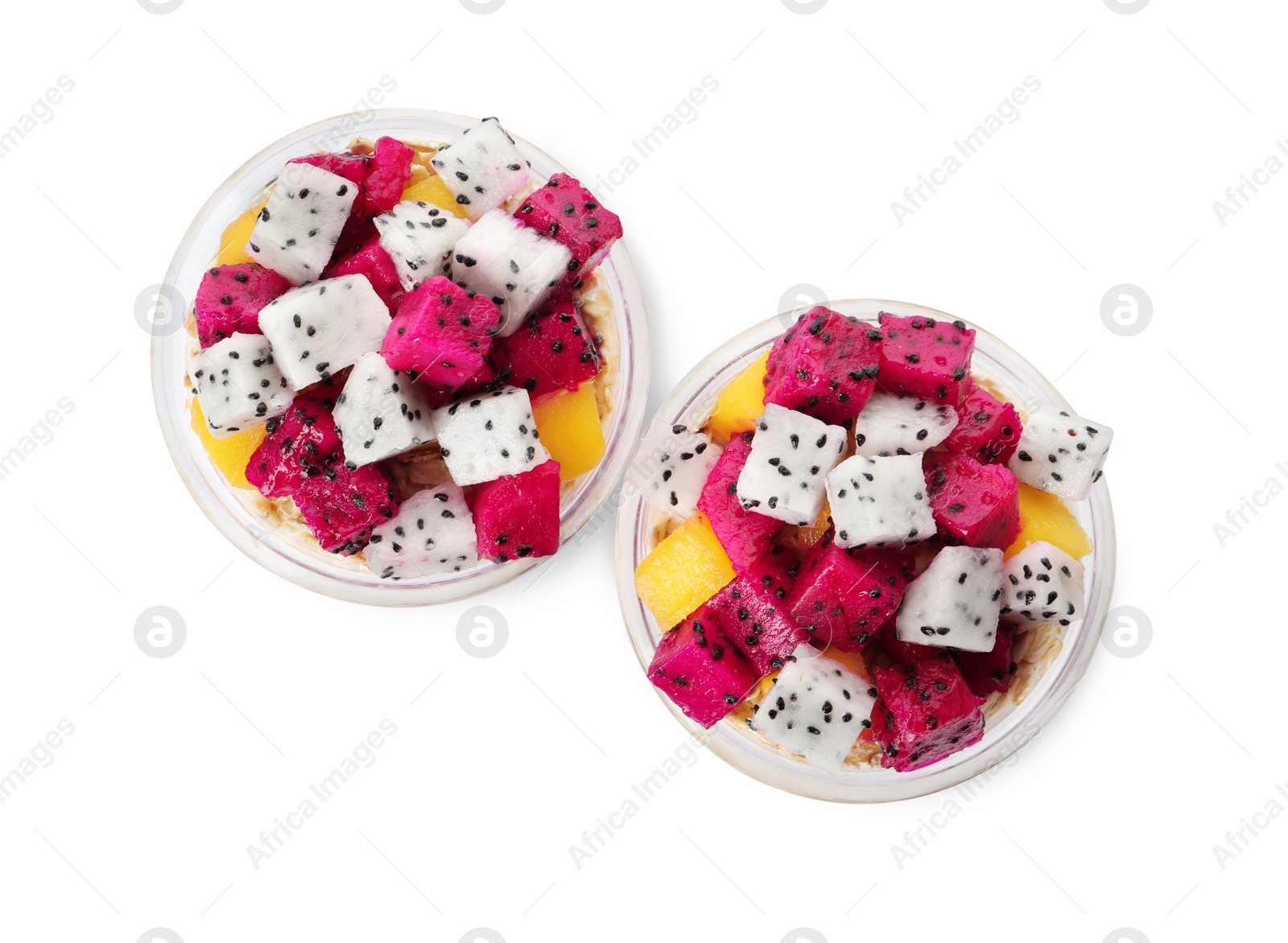 Photo of Glasses of granola with pitahaya and mango on white background, top view