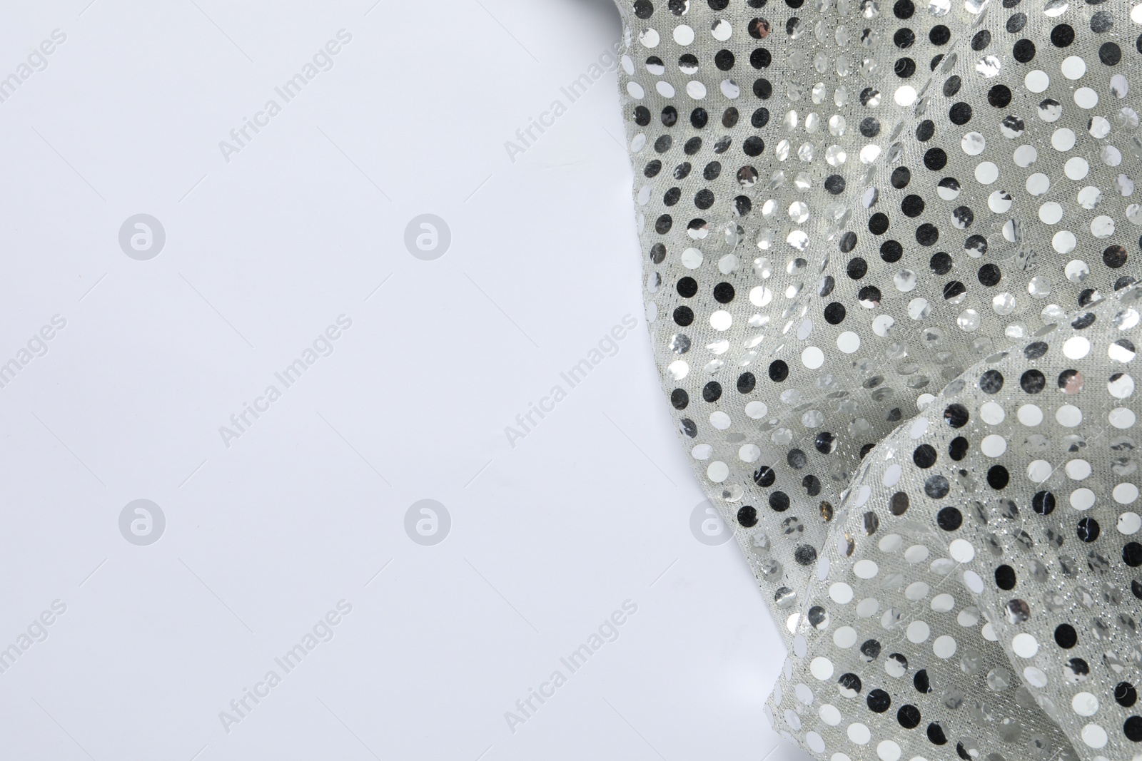 Photo of Shiny sequin fabric on white background, top view. Space for text