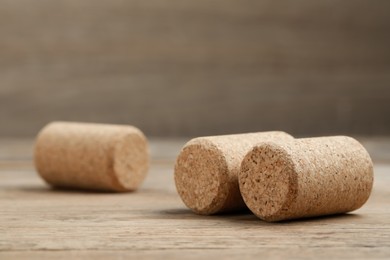 Photo of Corks of wine bottles on wooden table, closeup