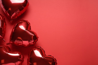 Photo of Heart shaped balloons on red background, flat lay with space for text. Valentine's Day celebration