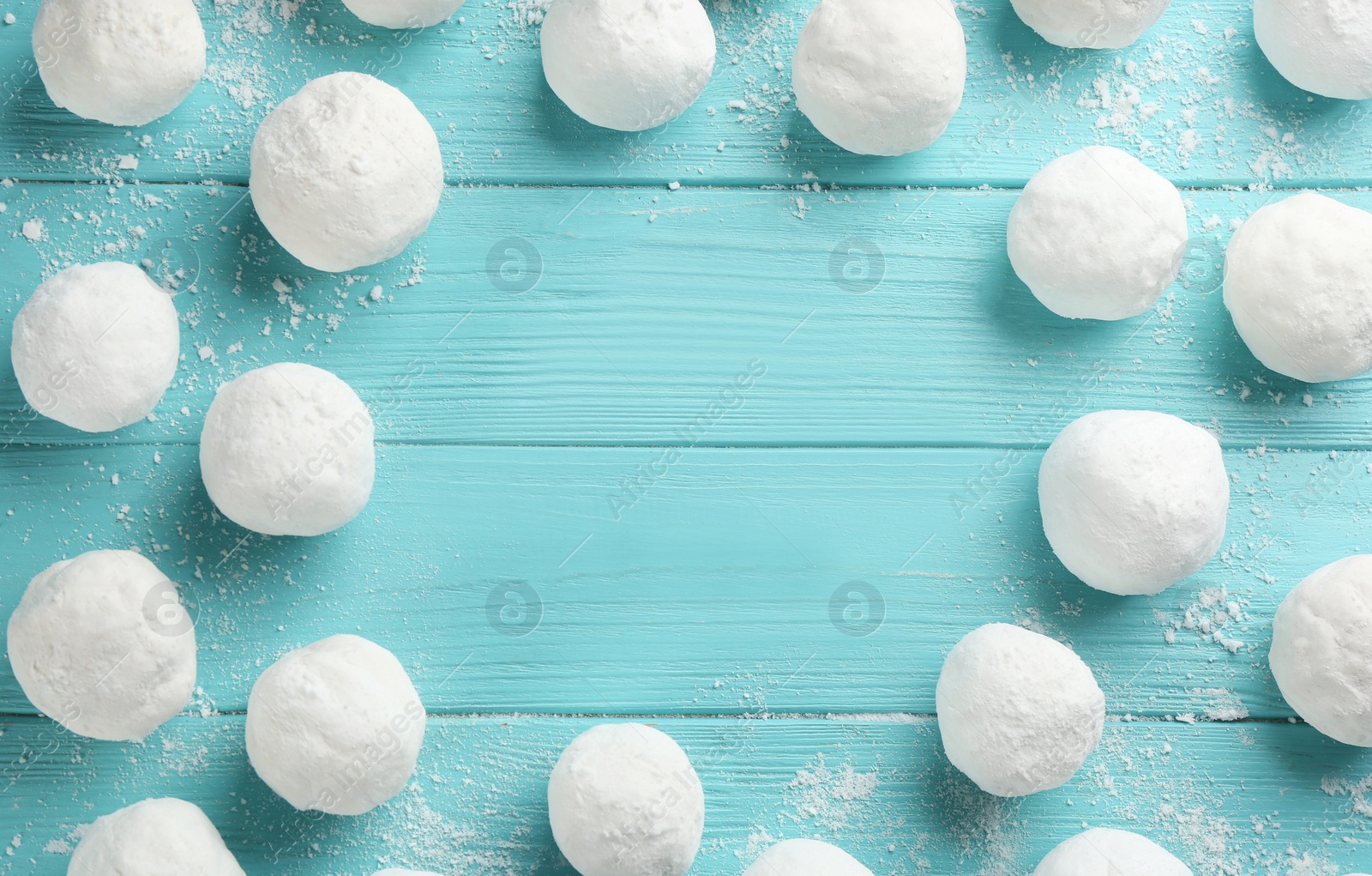 Photo of Frame of snowballs on light blue wooden background, flat lay. Space for text