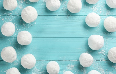 Frame of snowballs on light blue wooden background, flat lay. Space for text