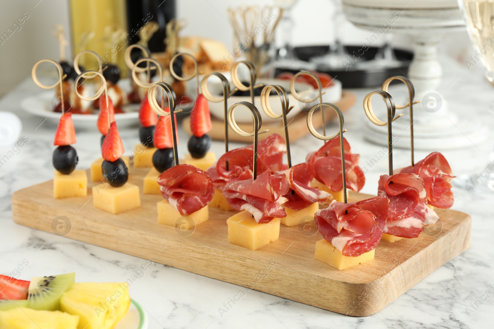 Photo of Different tasty canapes on white marble table, closeup